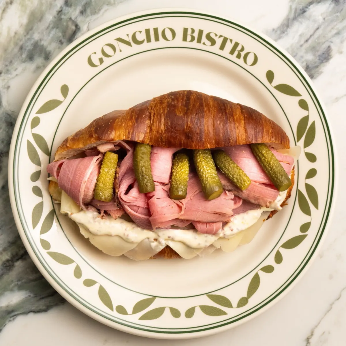 Cold pastrami croissant with swiss cheese and pickles