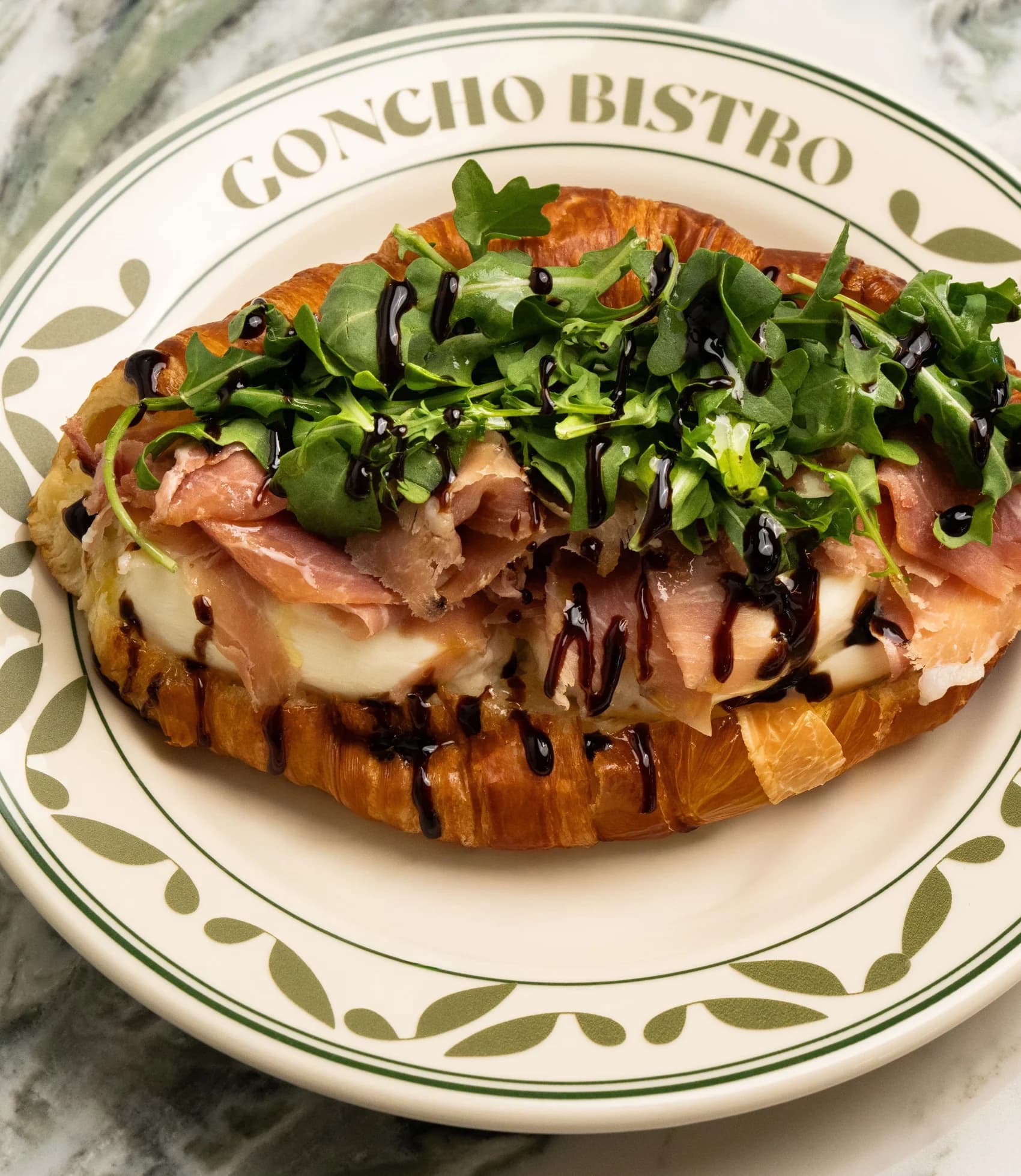 Fig jam and prosciutto croissant on a GONCHO BISTRO plate